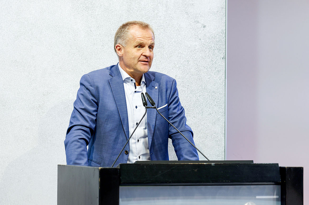 Dr. Stephan Fasshauer, Hauptgeschäftsführer Deutsche Gesetzliche Unfallversicherung e.V. (DGUV) und amtierender Vorsitzender der Nationalen Präventionskonferenz (NPK) Dr. Stephan Fasshauer, Hauptgeschäftsführer Deutsche Gesetzliche Unfallversicherung und amtierender Vorsitzender der Nationalen Präventionskonferenz steht am Rednerpult und führt in die Veranstaltung ein.
