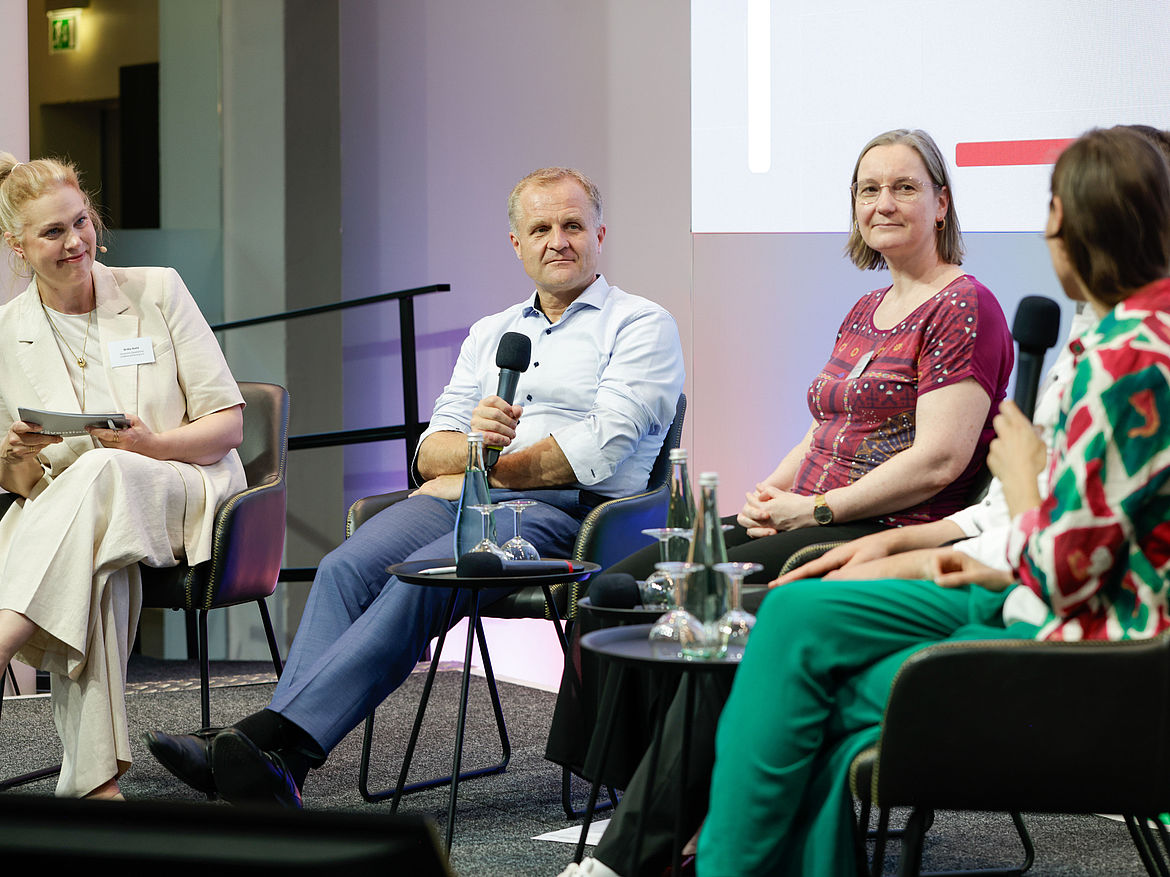 Fishbowl mit Moderatorin Ibald, NPK-Vorsitzendem Dr. Fasshauer, Referierenden Dr. Wegewitz und Prof. Dr. Thiemann sowie einer Teilnehmerin. Auf dem Podium sitzen eine Moderatorin, der diesjährige NPK-Vorsitzende, zwei Referierende und eine Teilnehmerin.
